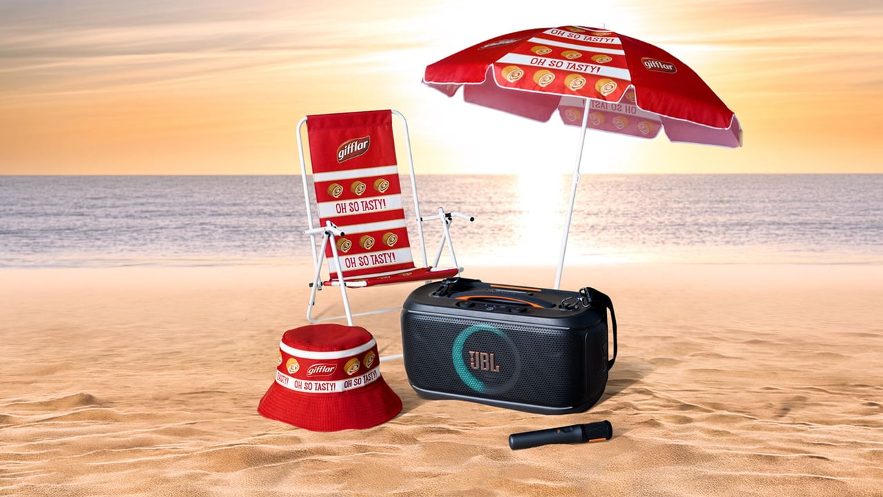 Gifflar sommarkit på stranden med havet och solen i bakgrunden