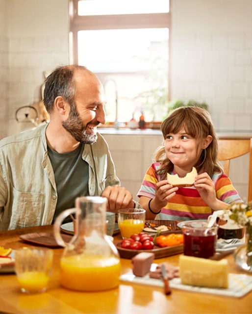 Bild på pappa och flicka som äter en macka